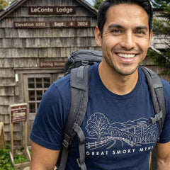 Man hiking a trail wearing a navy Great Smoky Mountains National Park Line Art Tshirt.