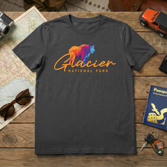 The Glacier – Mountain Goat Script T-Shirt in charcoal gray features a vibrant mountain goat graphic, making it an ideal Montana souvenir for adventurers and fans of Glacier National Park.
