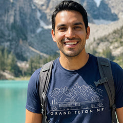 Man hiking a trail wearing a navy Grand Teton National Park Line Art Tshirt.