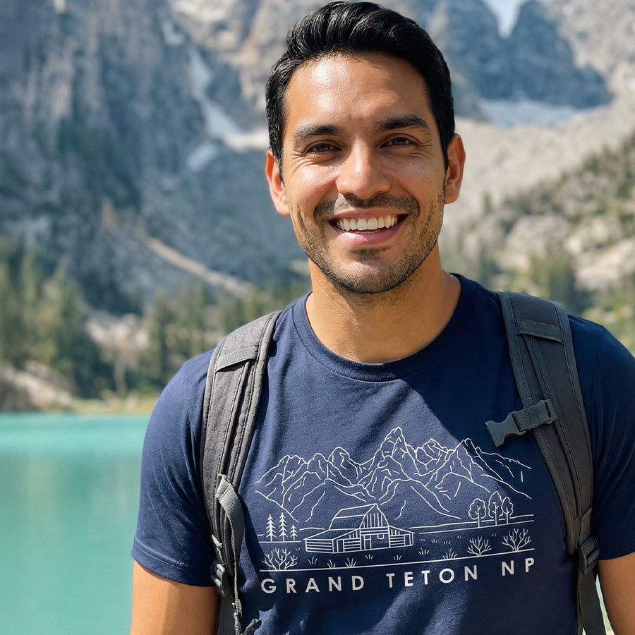 Man hiking a trail wearing a navy Grand Teton National Park Line Art Tshirt.