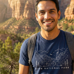 Man hiking a trail wearing a navy Zion National Park Line Art Tshirt.