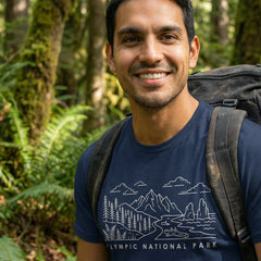 Man hiking a trail wearing a navy Olympic National Park Line Art Tshirt.