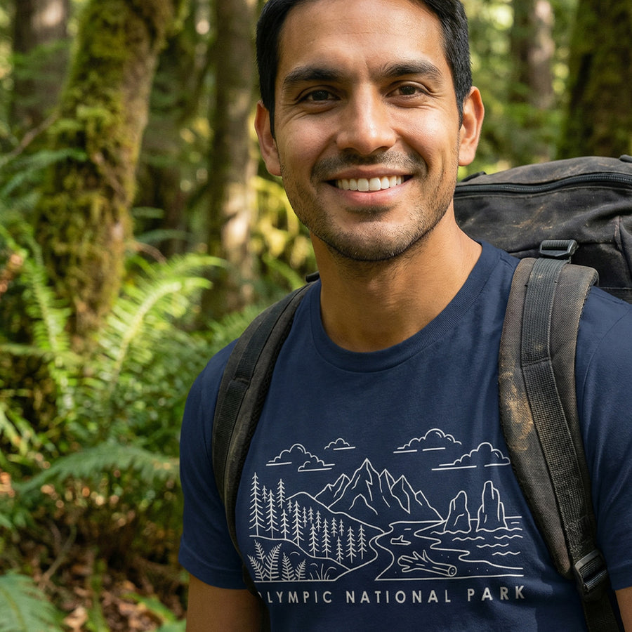 Man hiking a trail wearing a navy Olympic National Park Line Art Tshirt.
